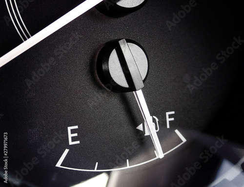 Fuel gauge with needle indicator on dashboard in a car.