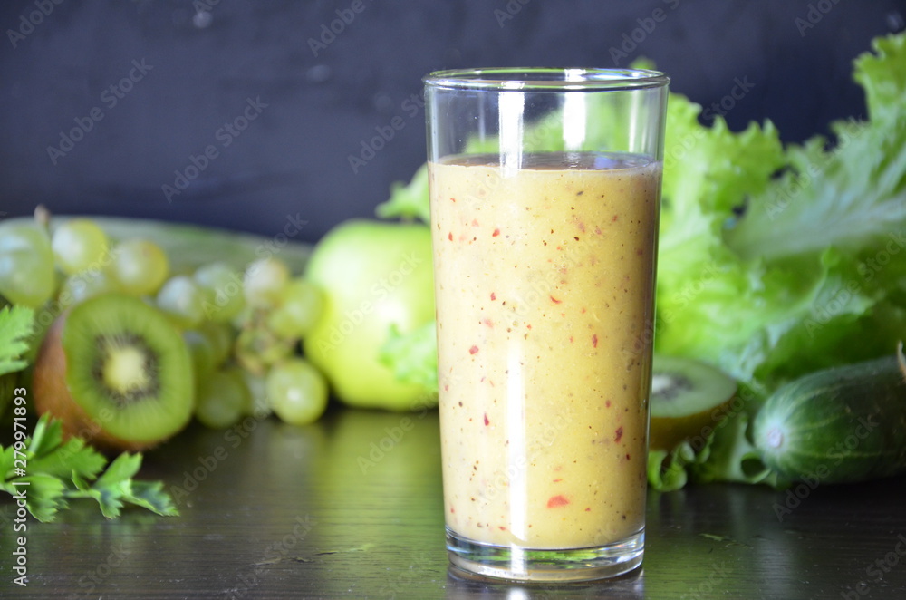 Health Drink and Smoothie Diet. Green fruits and vegetables on a black background. Kiwi, green grapes, lettuce, zucchini, cucumbers, green apple, parsley with spinach top view selective focus Health Drink and Smoothie Diet. Green fruits and vegetables on a black background. Kiwi, green grapes, lettuce, zucchini, cucumbers, green apple, parsley with spinach top view selective focus