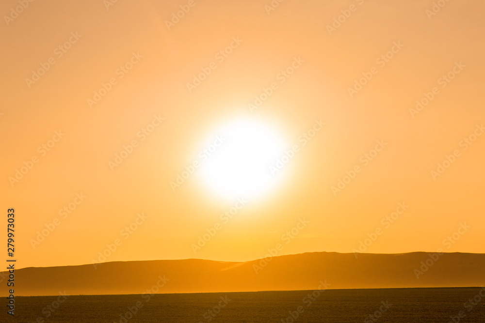 Obraz premium Beautiful sunrise in the desert. Bright sunlight. Silhouette of mountains