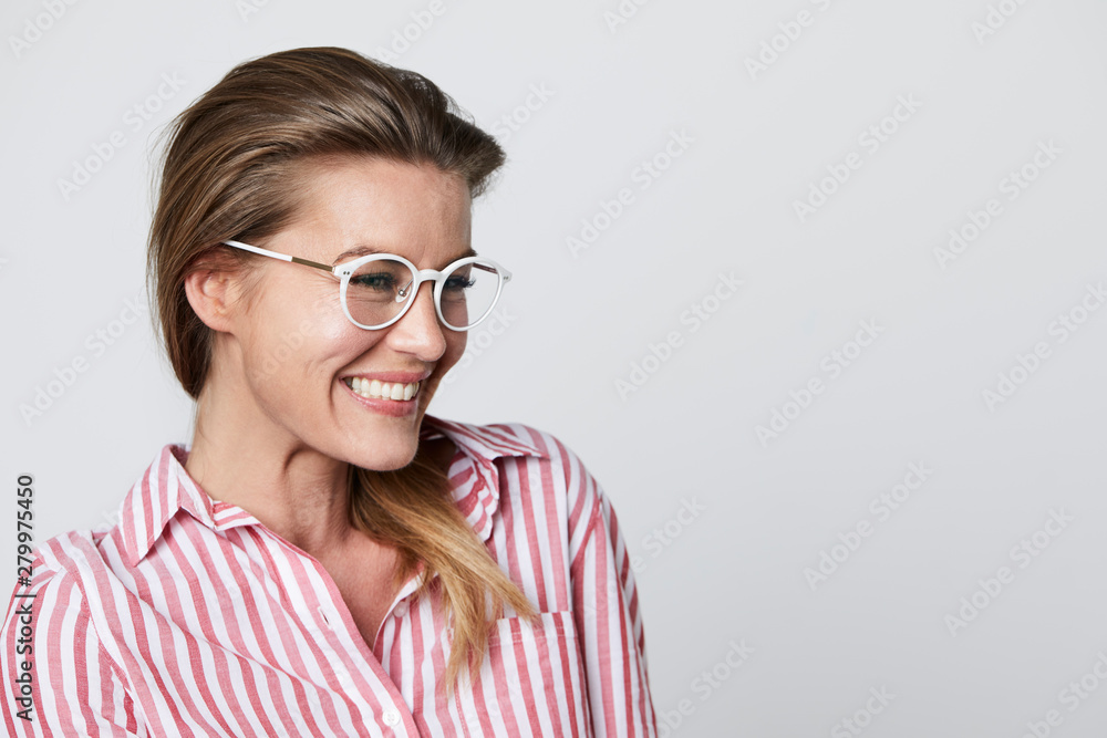 Glasses woman smiling in striped shirt, looking away