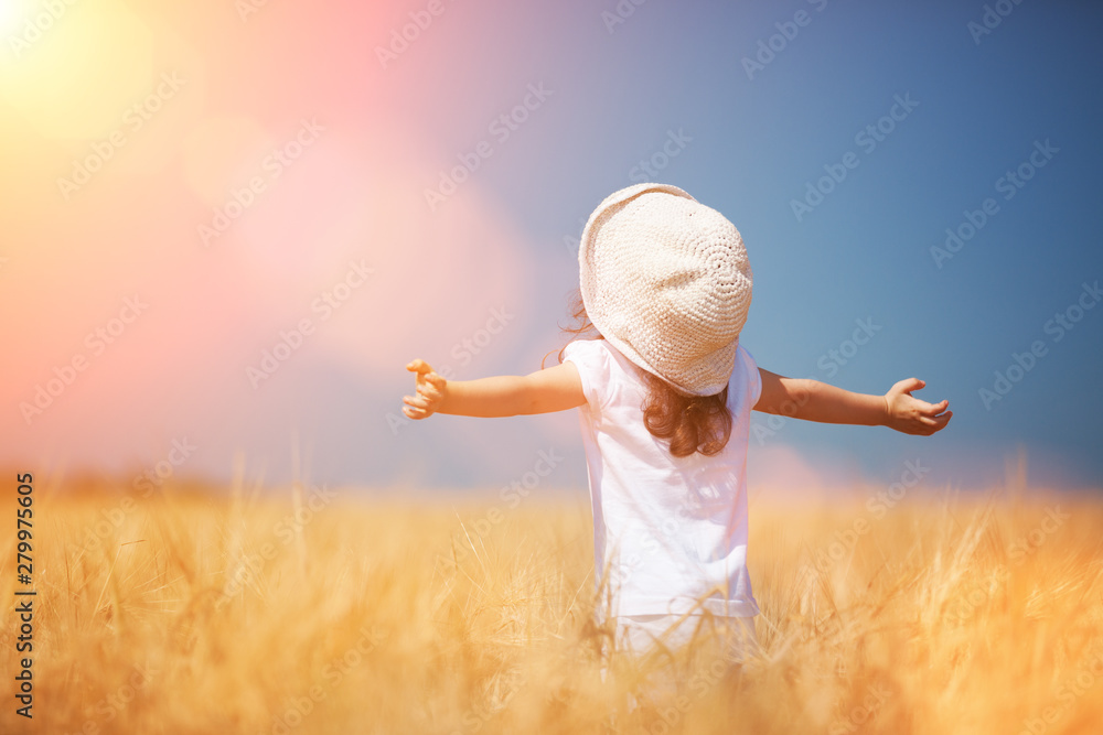 Happy girl walking in golden wheat, enjoying the life in the field. Nature beauty, blue sky and field of wheat. Family outdoor lifestyle. Freedom concept. Cute little girl in summer field Happy girl walking in golden wheat, enjoying the life in the field. Nature beauty, blue sky and field of wheat. Family outdoor lifestyle. Freedom concept. Cute little girl in summer field