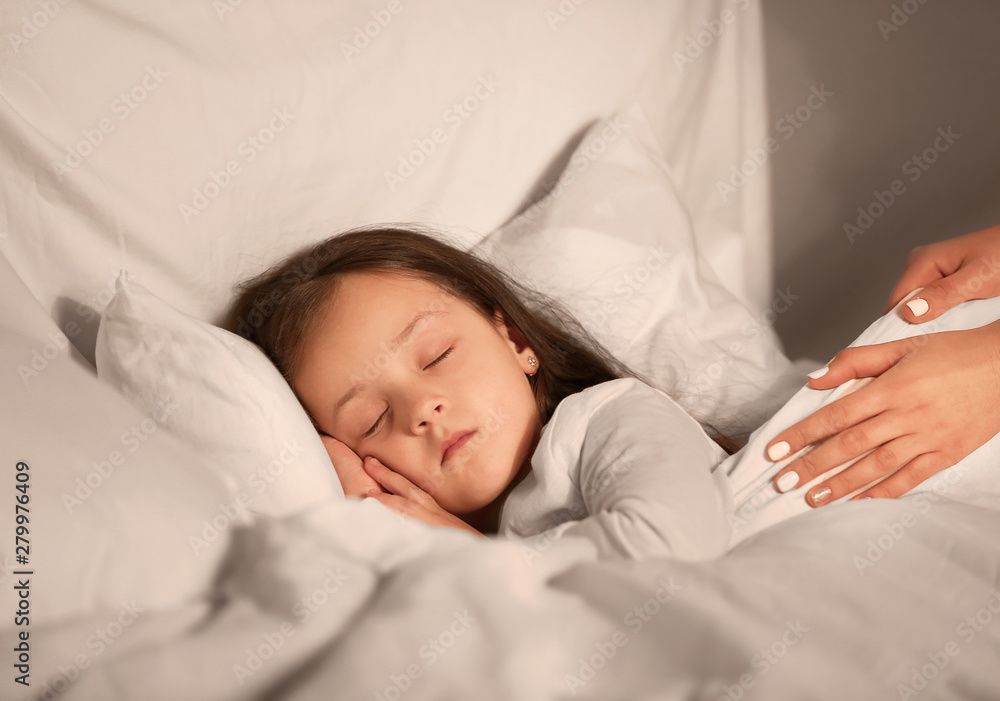 Woman putting her little daughter to bed Woman putting her little daughter to bed