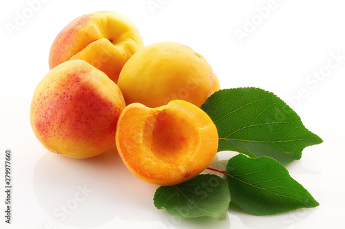 Ripe juicy fruits and green leaves of apricot close up isolated on white background