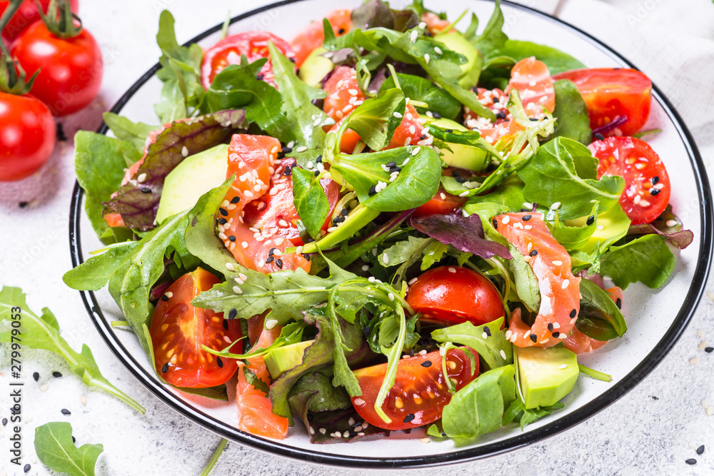 Salmon salad with fresh vegetables on white.