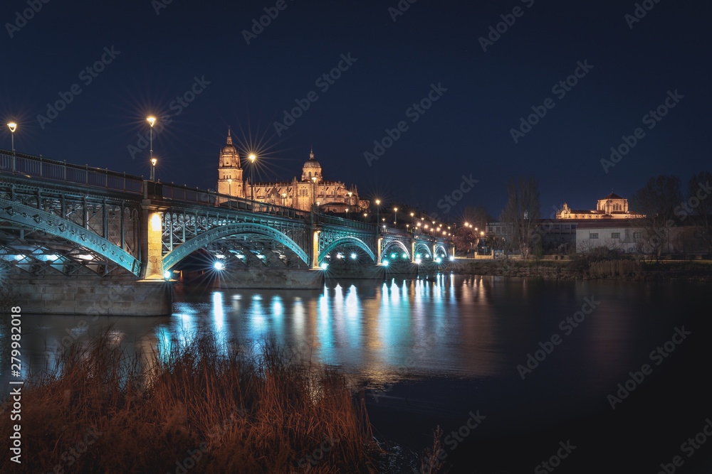 Salamanca Skyline view with Cathedral and Enrique Estevan Bridge from Tormes River at night - Salamanca, Castile and Leon, Spain