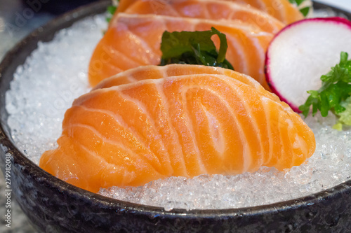 salmon sashimi on ice in black bowl japanese food