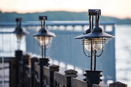 Lampiony, latarnie na pomoście nad wodą o wschodzie słońca