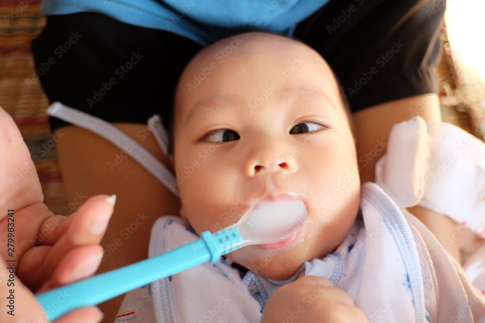 Mom is feeding baby food with silicone spoon. Mom is feeding baby food with silicone spoon.