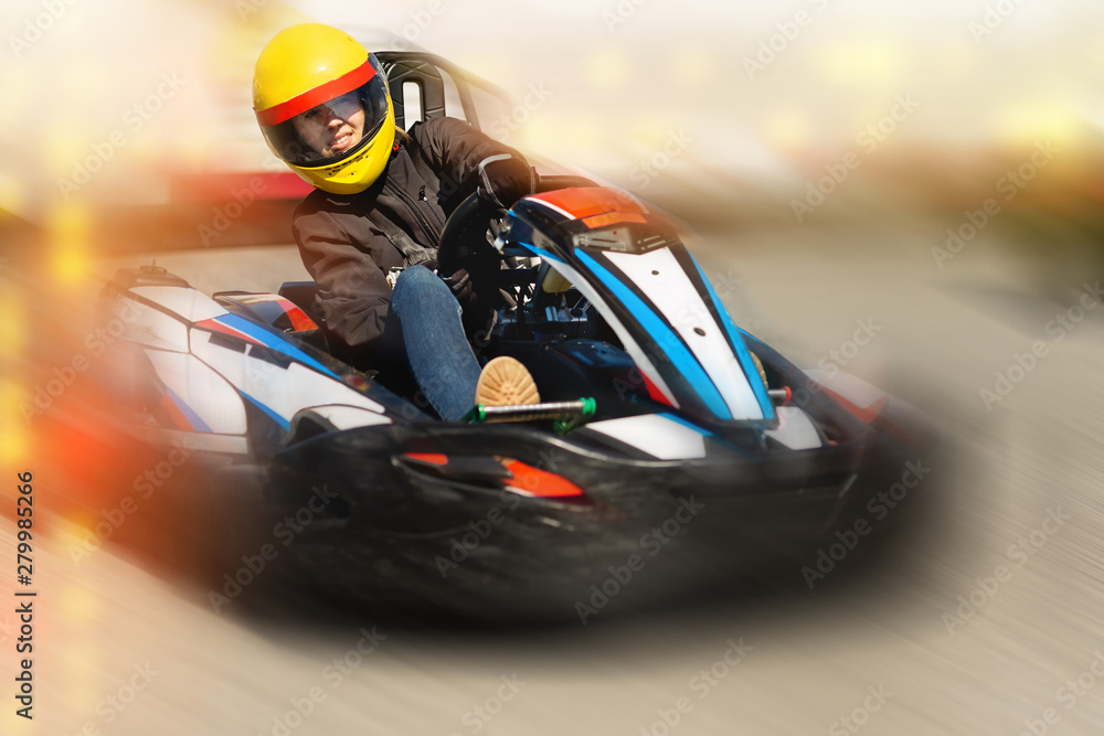 Girl driving kart at racing track outdoors