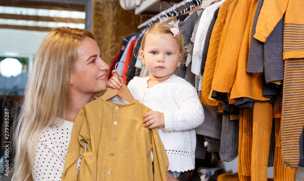 Mother and daughter choosing baby clothes