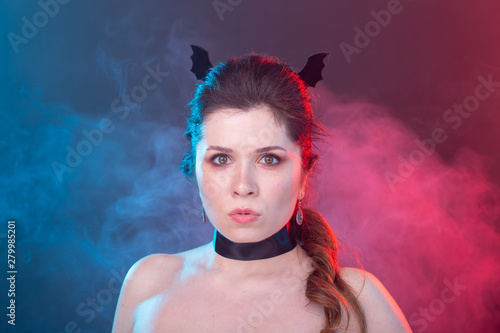 Halloween, holidays and carnival concept - vamp woman in collar and bat's ears in gothic style