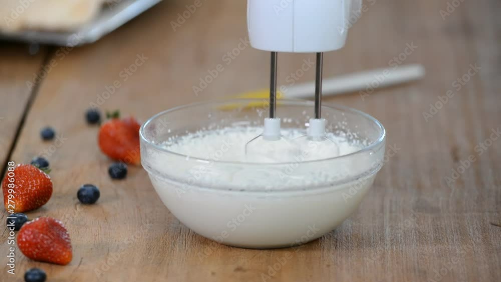 Whipping cream with a mixer. Bubbles on cream. Whipping cream with a mixer. Bubbles on cream.