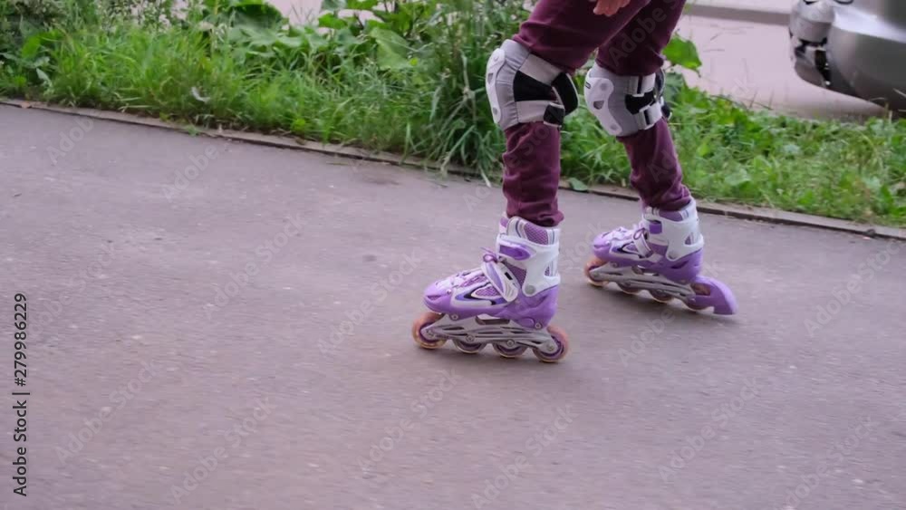 Teenage roller skating, close-up only rollers and legs Teenage roller skating, close-up only rollers and legs