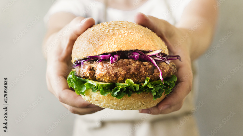 Close-up cook holding burger in hands Close-up cook holding burger in hands