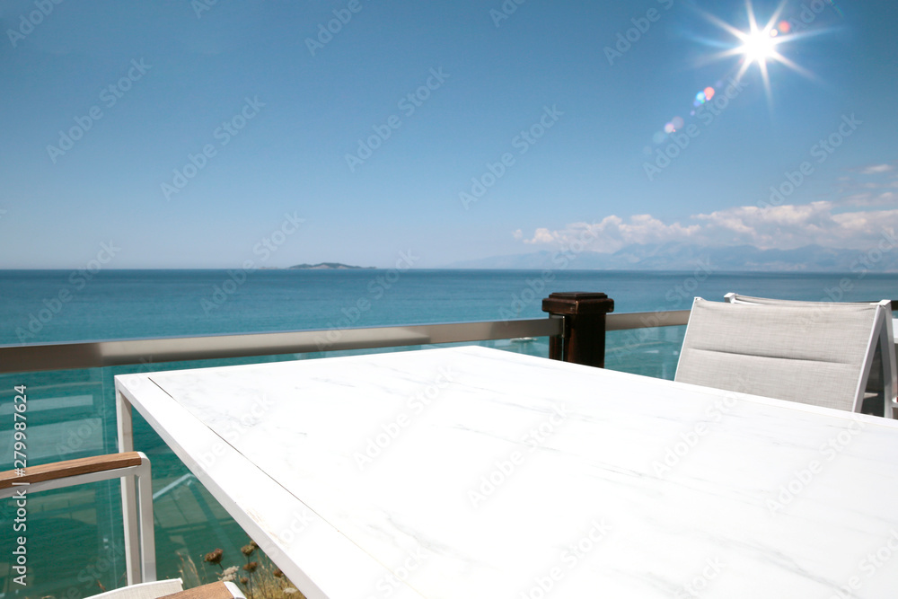 A white table background on a balcony  on a beautiful sunny blue sky and ocean view,