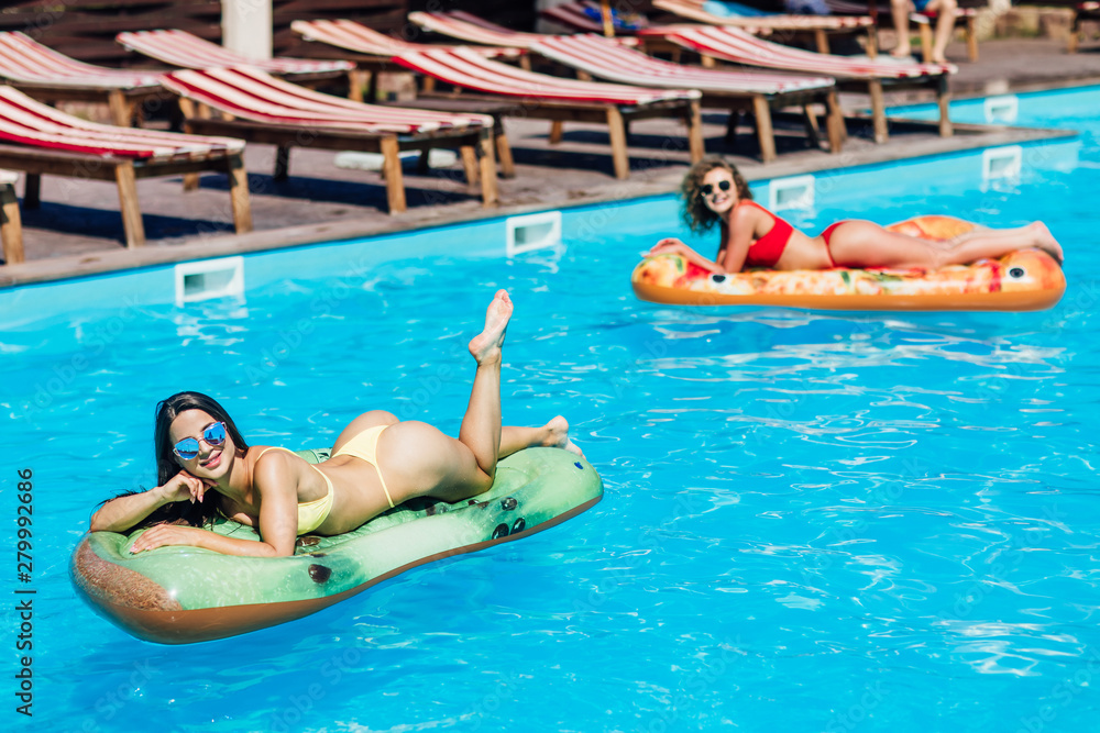 Photo of twogirls lying on modern matrass and posing to the camera.