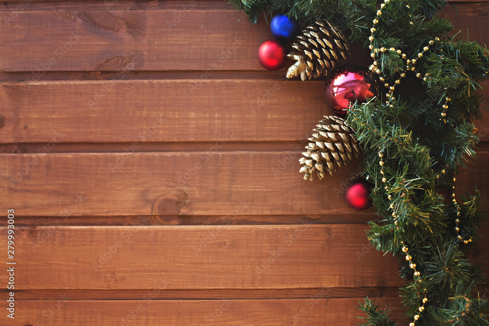 New Year Christmas tree garland decorated with golden cones and multi-colored balls on a wooden background New Year Christmas tree garland decorated with golden cones and multi-colored balls on a wooden background