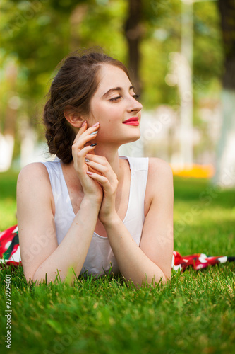 Gorgeous young pretty woman relaxing in summer park