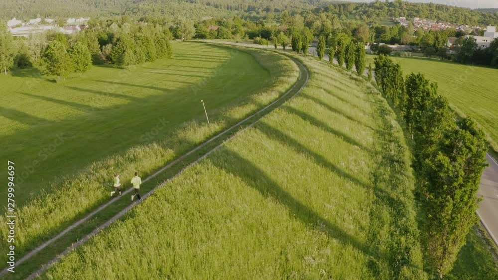 Tracking shot of couple running through fields Tracking shot of couple running through fields