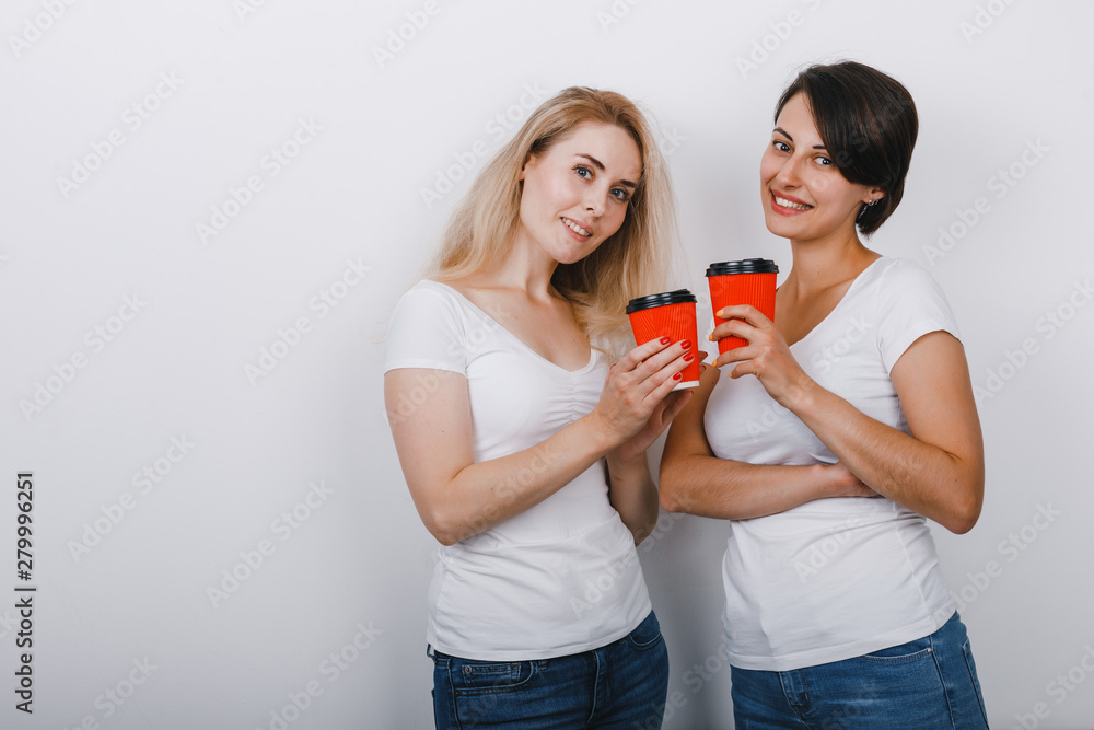 Portrait of two women friends raised glasses of coffee and looking gently at the camera Portrait of two women friends raised glasses of coffee and looking gently at the camera
