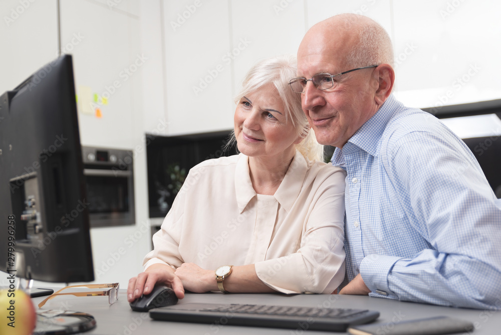 Happy elder couple enjoy together at computer Happy elder couple enjoy together at computer