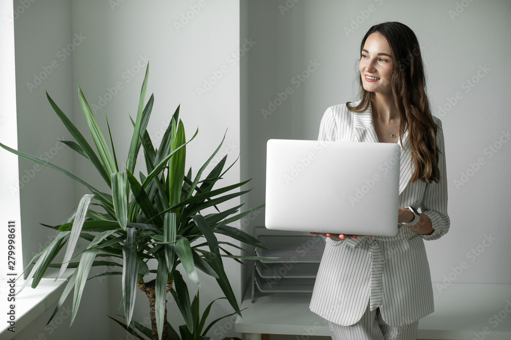 girl in the office holding a laptop girl in the office holding a laptop