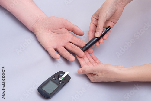 Doctor use blood glucose detector for patient