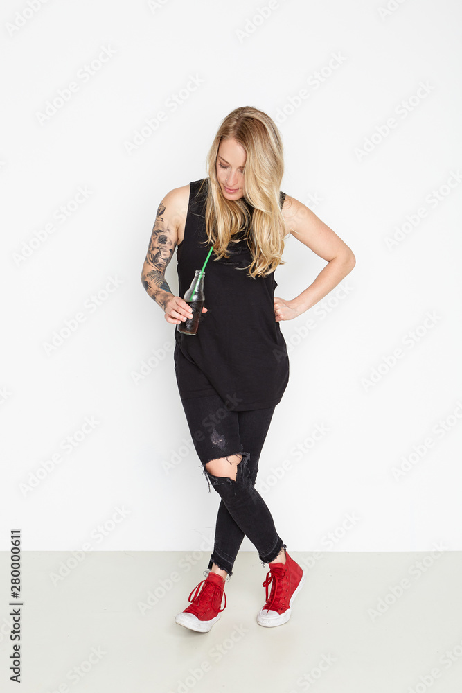 Beautiful young woman holding a bottle of soda on the white background Beautiful young woman holding a bottle of soda on the white background