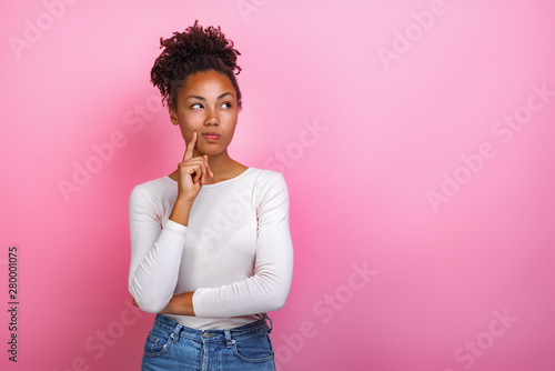 Fototapeta Studio portrait of a thinking pose girl touching herself face by index finger- I