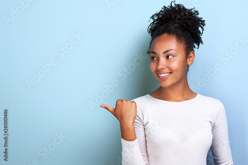 Attractive young woman pointing by her finger sideways place for copy space photo