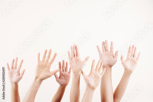 Close-up of crowd of people stretching their hands up they voting over white background