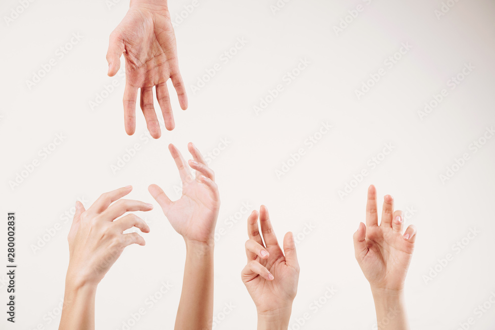 Close-up of young people stretching hands and supporting each other isolated on white background Close-up of young people stretching hands and supporting each other isolated on white background