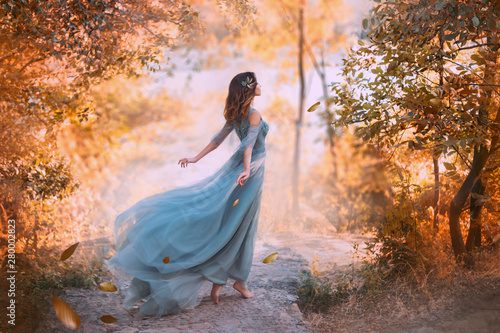 Obraz na plátně delightful light girl in sky blue turquoise dress with long flying train, princess of wind and daughter of storm, lady with dark hair throws fallen leaves to ground, autumn story in art processing