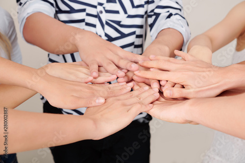 Close-up of people standing in circle and stretching their hands to each other they demonstrating unity