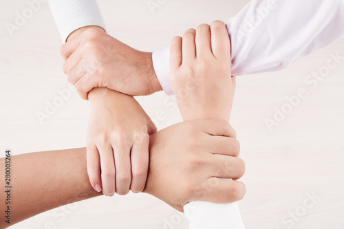 Close-up of people holding each other for hands isolated on white background