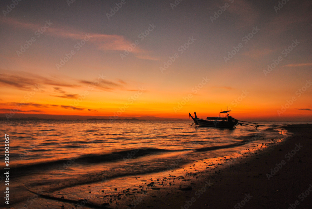 Morning light with peaceful Koh Lao Liang beach with a boat ready to travel to the sea.