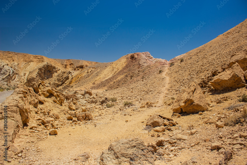 desert canyon dry scenery landscape with lonely ground trail between sharp stones and rocks