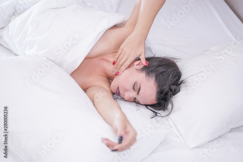 charming young brunette girl resting in her white bed