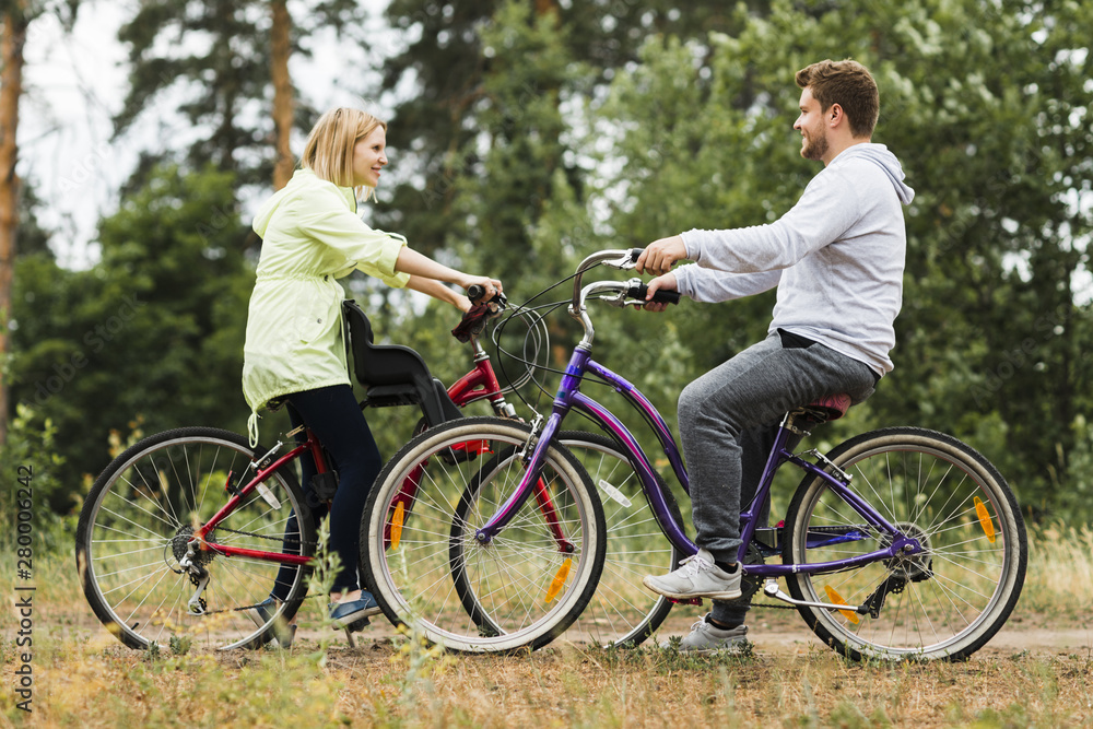 Sideways happy couple on bicycles