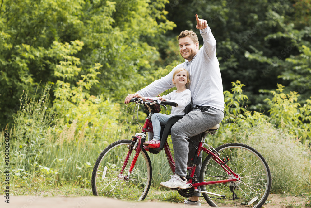 Father on bicycle pointing for daughter