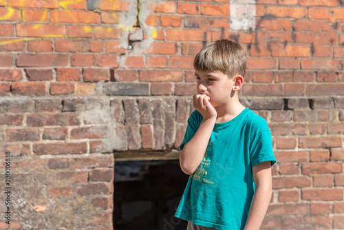 Children in an abandoned and destroyed building in the zone of military and military conflicts. The concept of social problems of homeless children. Staged photo.