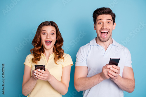 Close-up portrait of his he her she nice attractive lovely cheerful cheery ecstatic people using 5g app blog smm internet online speed isolated over bright vivid shine blue green background
