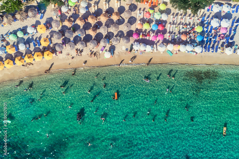 Aerial View of the Aliki Beach with colorful umbrellas, at Thassos island, Greece