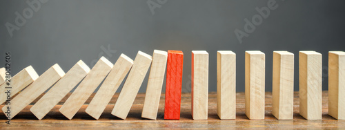 Wooden blocks and the effect of dominoes. Risk management concept. Successful strong business and problem solving. Reliable leader. Stop the destructive processes. Strategy development. photo