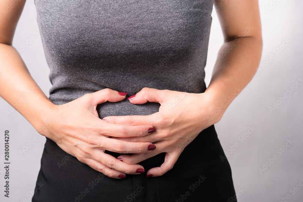 Foto de A beautiful woman holding her stomach, symptom of sickness