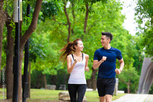 Fototapeta Naklejka Na Ścianę i Meble -  happy young Couple jogging and running  in park