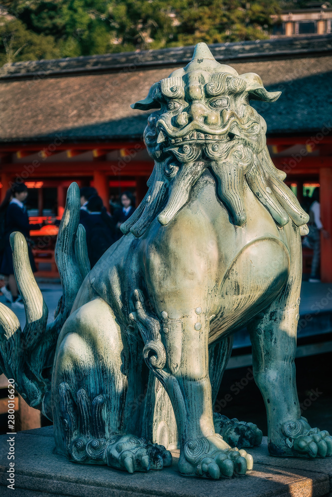 A Komainu Bronze Lion sculpture, the guarding creature protecting the entrance at Itsukushima Shrine on Miyajima Island, Hiroshima Bay, Japan.