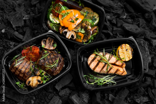 Set of grill cooked meat, fish and vegetables on coal background