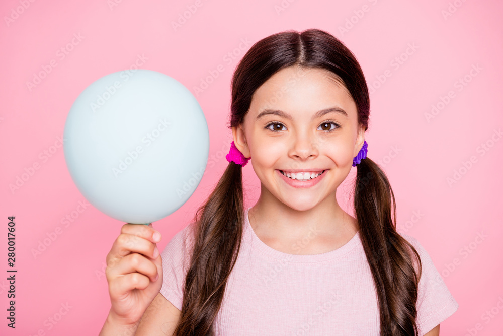 Close up photo of sweet child holding baloon looking wearing white t-shirt isolated over pink background Close up photo of sweet child holding baloon looking wearing white t-shirt isolated over pink background