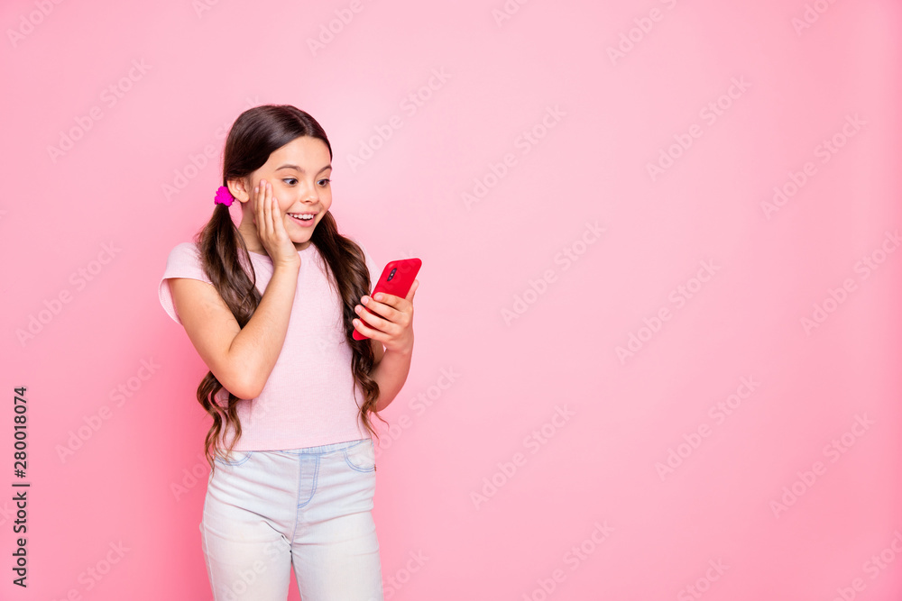 Portrait of impressed kid shouting screaming holding device looking wearing pants trousers white t-shirt isolated over pink background Portrait of impressed kid shouting screaming holding device looking wearing pants trousers white t-shirt isolated over pink background